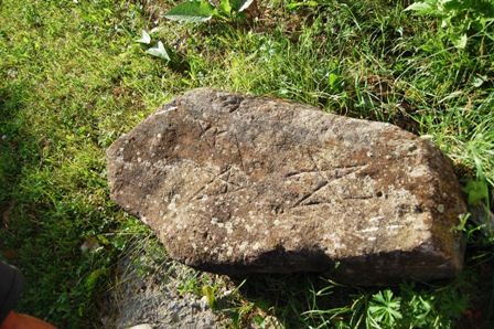 Rovásírásos kő a templomkertben